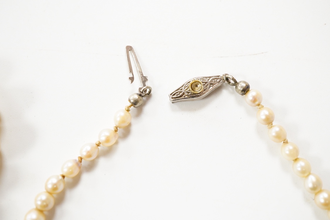 Two single strand graduated cultured pearl necklaces, one with a single stone rose cut diamond set 9ct white metal clasp, 42cm, together with a simulated pearl necklace and three assorted costume brooches.